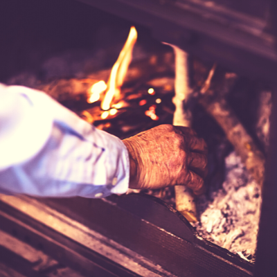 hand putting wood on fire