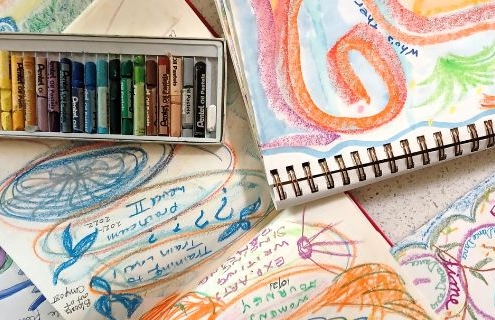 Drawings with writing on them along with pastels